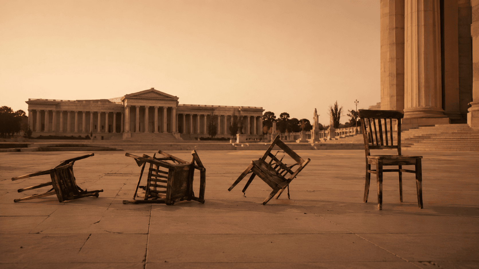 Conceptual photograph showing four wooden chairs in an architectural plaza — three tipped over or cracked, one upright but isolated — representing four investor visa programs that have been abolished between 2022 and 2025. Stark neoclassical setting, late-afternoon light, monochromatic warm palette.